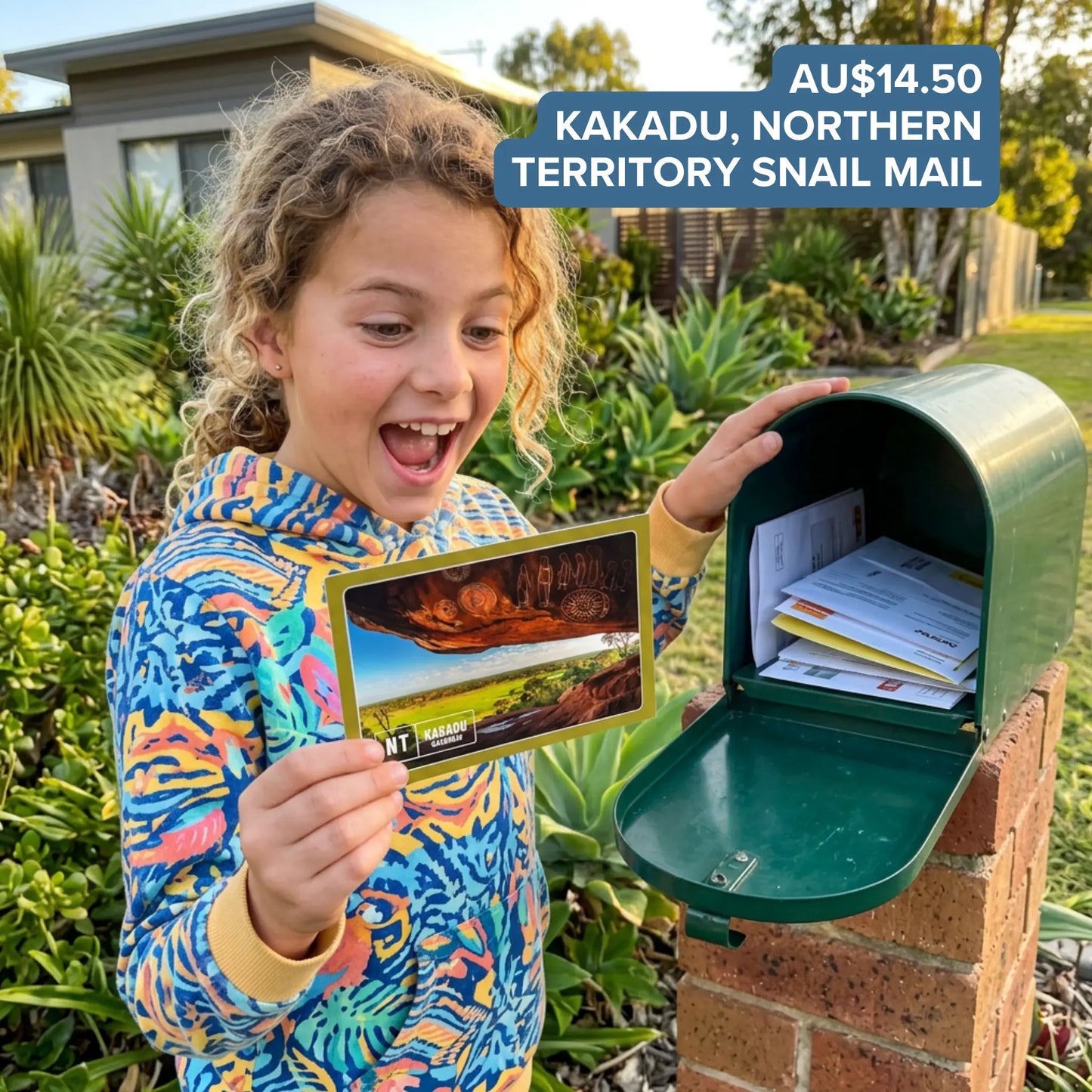 Child excitedly holding a Kakadu, Northern Territory postcard featuring Aboriginal rock art beside an open mailbox full of Snail Mail envelopes.