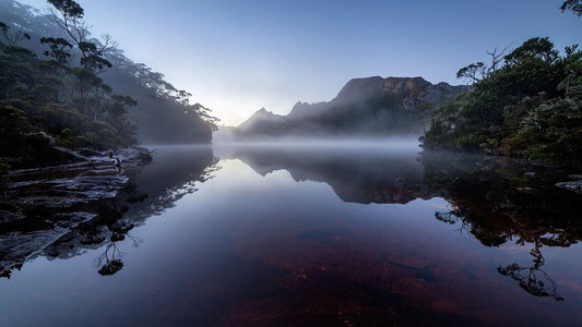 Cradle Mountain reflected in the still, misty waters of Dove Lake at dawn, Tasmania
