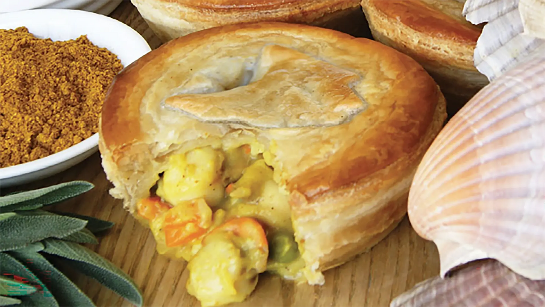 Golden Tasmanian scallop pie with pastry cut open, revealing curried scallops, vegetables and creamy sauce